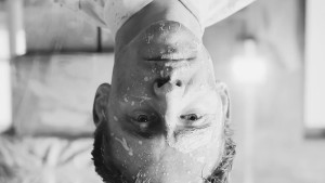 Tom Hiddleston upside down with paint on his face