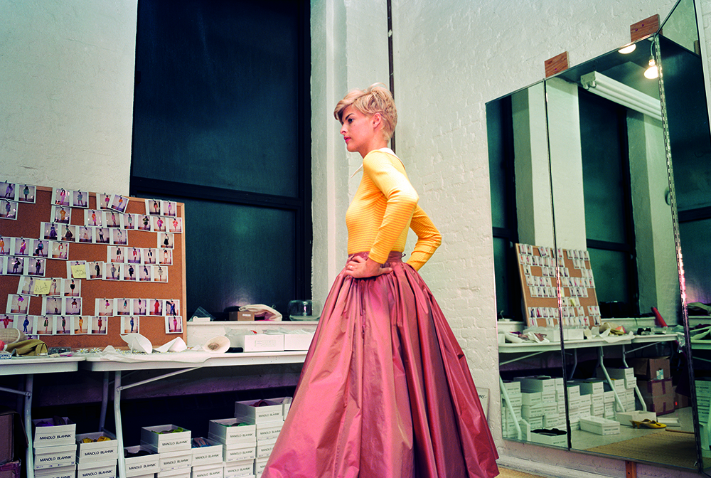 isaac mizrahi fashion, model backstage in yellow shirt and pink skirt