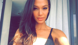 woman taking selfie with long hair in front of a curtain
