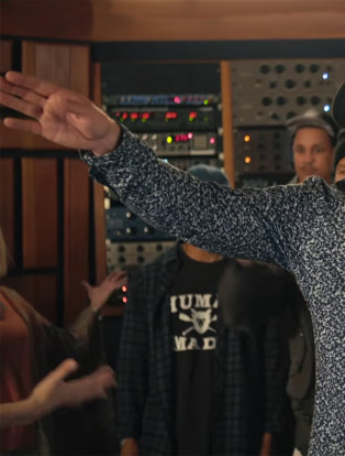 justin timberlake with arms up wearing a fedora and floral print shirt