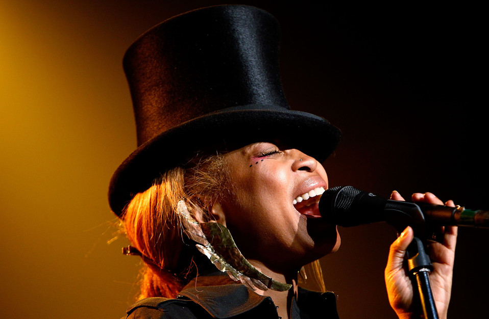 female performer singing into a microphone and wearing a top hat