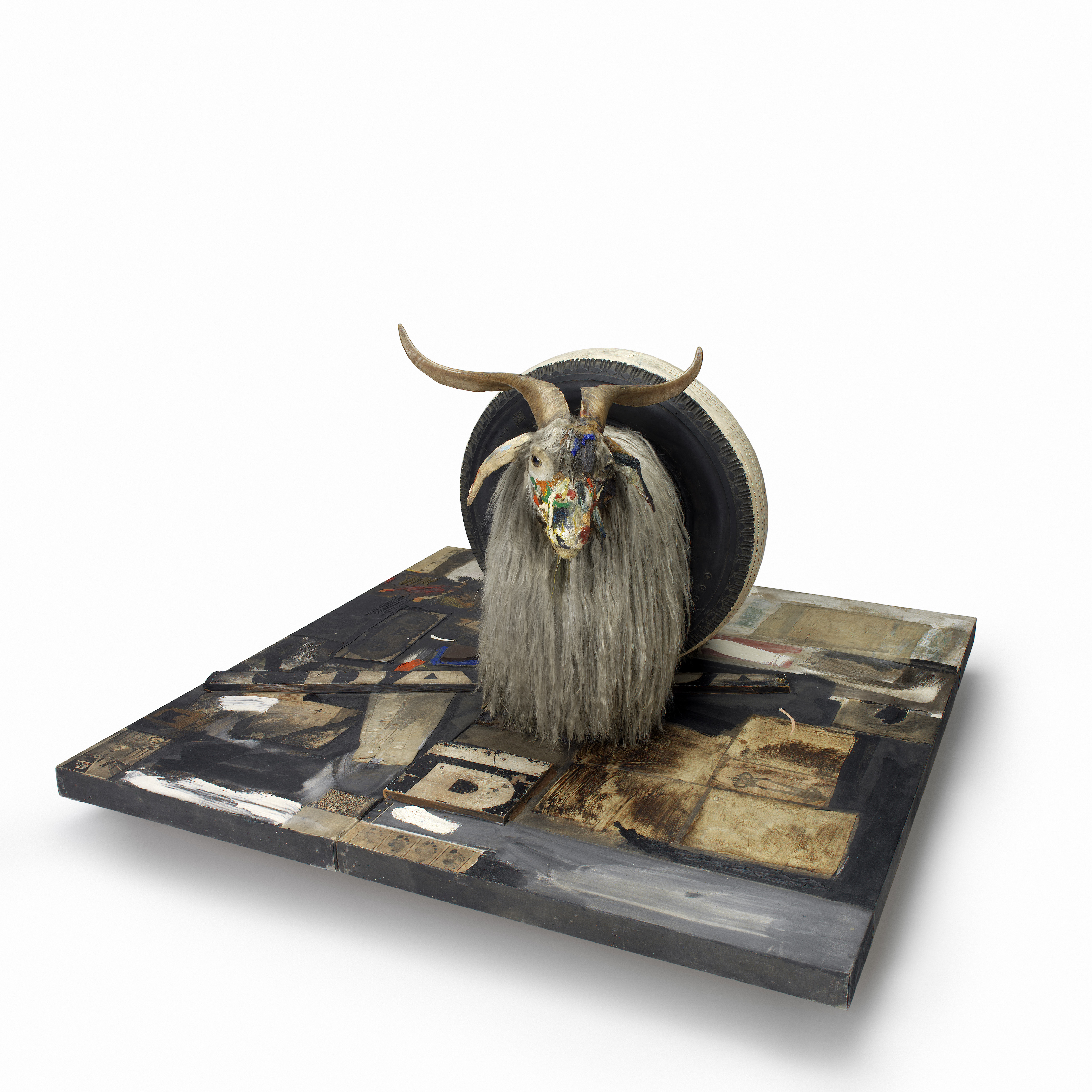 Monogram (1955–59), by Robert Rauschenberg. Combine: oil, paper, fabric, printed reproductions, metal, wood, rubber shoe-heel and tennis ball on two conjoined canvases with oil on taxidermied Angora goat with brass plaque and rubber tire on wood platform mounted on four casters. 106.7 x 135.2 x 163.8 cm. Moderna Museet, Stockholm. © Robert Rauschenberg Foundation, New York.
