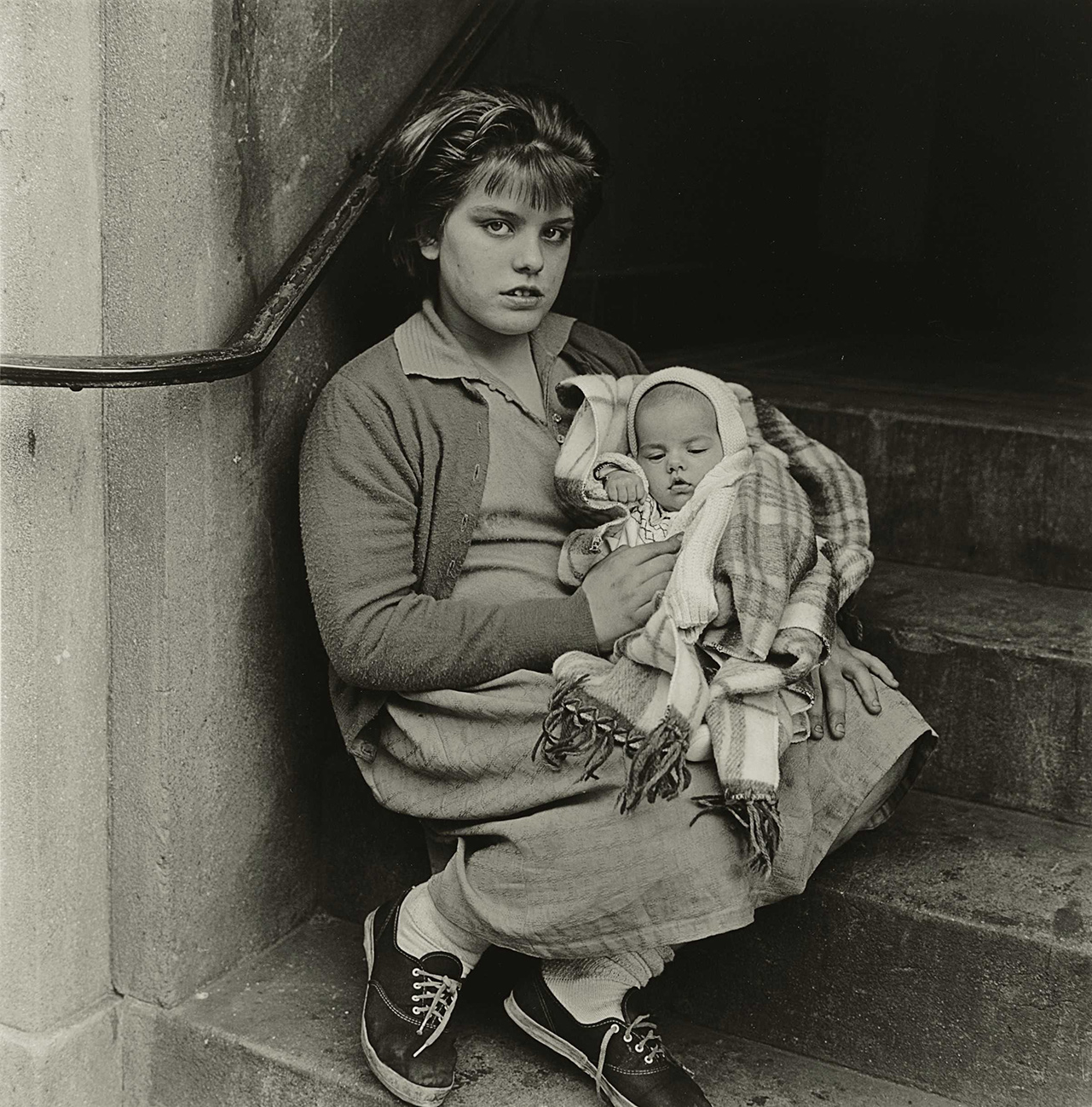 Diane Arbus girl holding baby in stairway