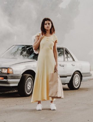 Petra Collins long yellow dress broken down car