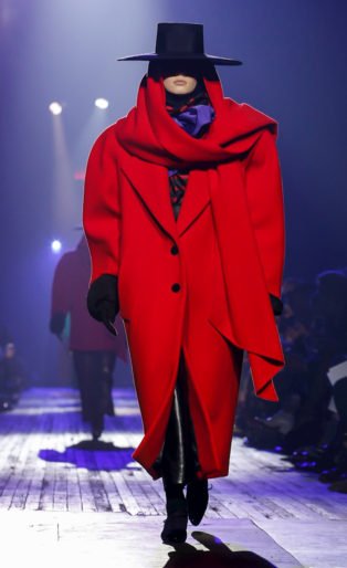 Photo of model in oversized red coat and flamenco black hat from Marc Jacobs Runway Show featuring Marc Jacob's Ready to Wear Collection for Fall/Winter 2018 in NYC
