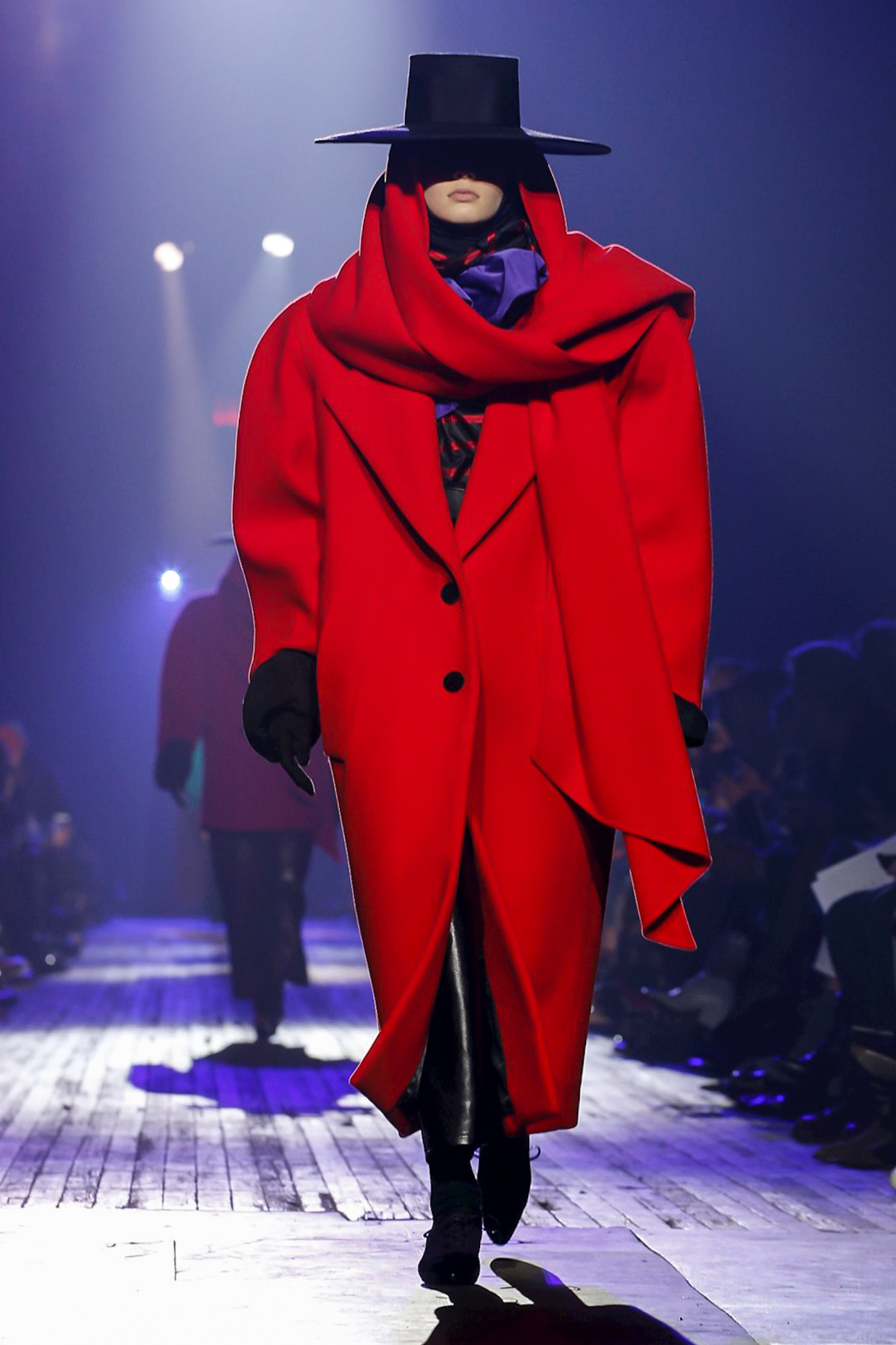 Photo of model in oversized red coat and flamenco black hat from Marc Jacobs Runway Show featuring Marc Jacob's Ready to Wear Collection for Fall/Winter 2018 in NYC