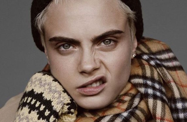 Cara Delevigne wearing a burberry scarf and snarling at the camera