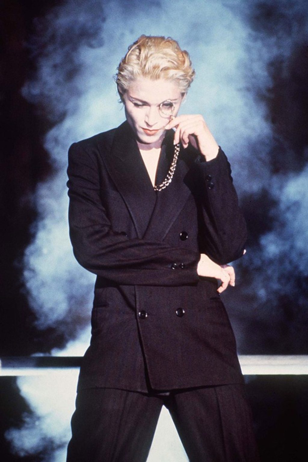 Madonna Gaultier Express Yourself Wearing a Black Suit and Holding a Monocle