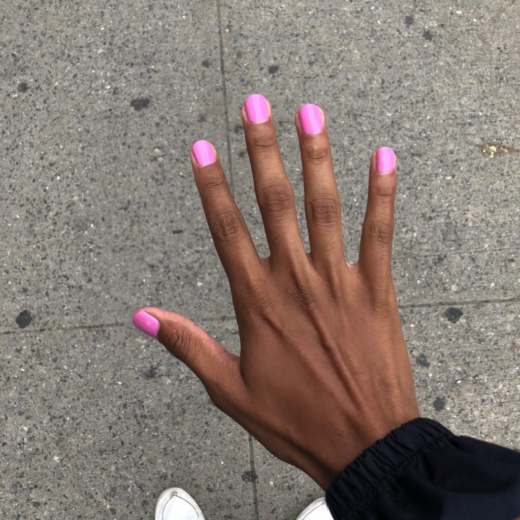 Tyler Mitchell photograph of a women's hand with hot pink painted nails