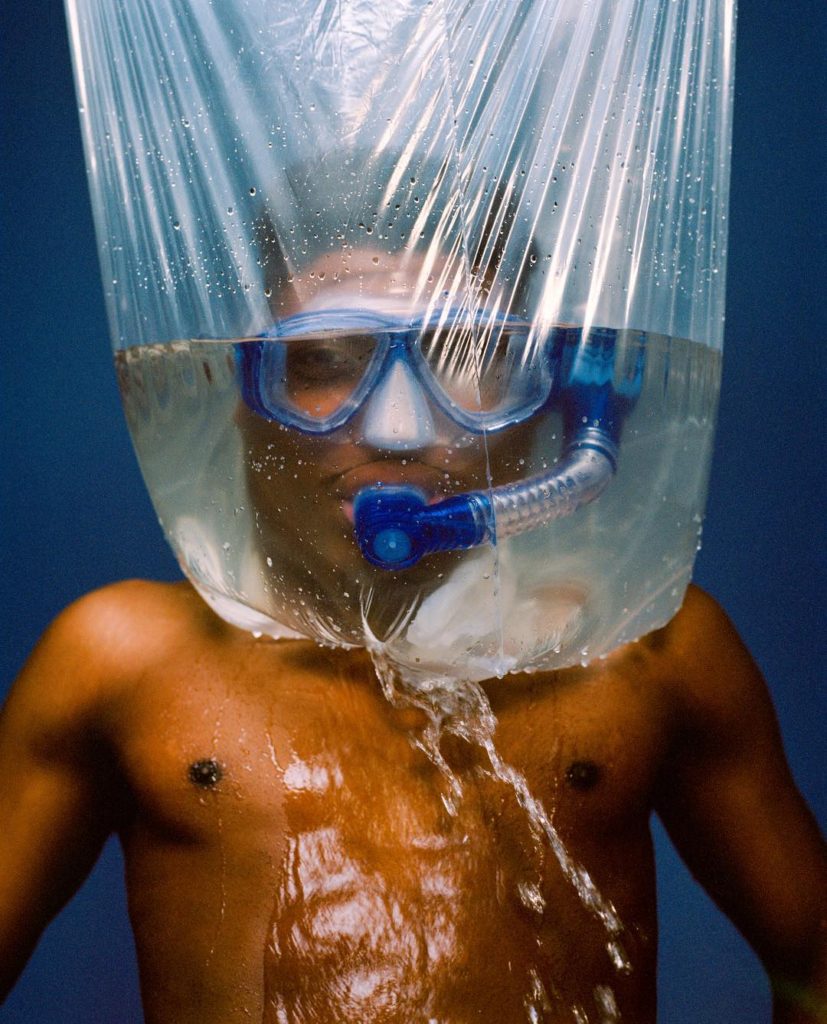 Tyler Mitchell photograph of a Man wearing mask and snorkel in a bag filled with water