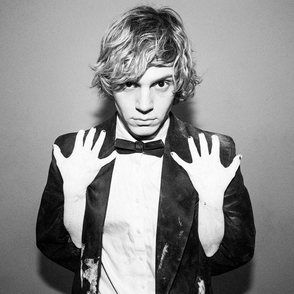 Photographer Tyler Shields Photograph of Cute Boy Wearing a Bow Tie and Tuxedo Jacket with his arms and hands behind him and women's hands coming from the back holding on to the jacket lapels 