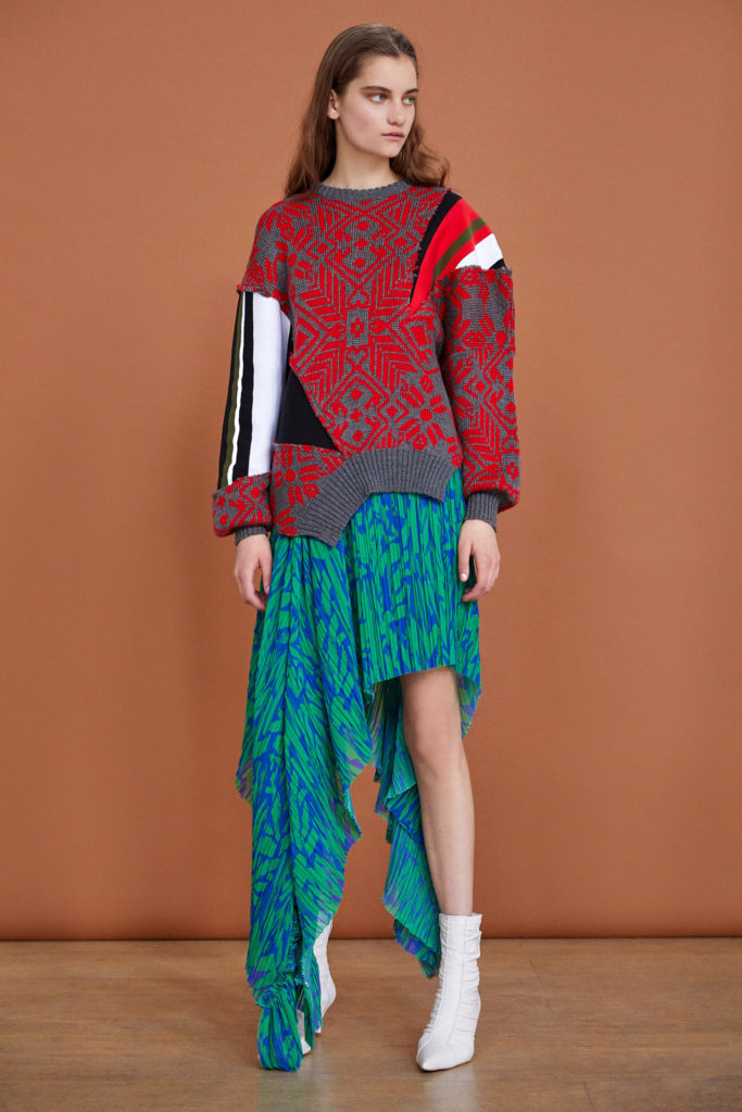 Female model wearing Red and Grey Norwegian Print Sweater with Black and White Striped Left Sleeve, Green and Blue Sarong and white ankle boots by Preen by Thornton- Bregazzi-Resort 2019