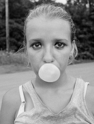 Teen blows bubble with gum
