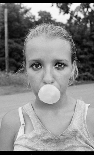 Teen blows bubble with gum