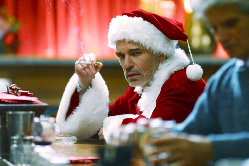 Billy Bob Thornton as Bad Santa sitting at a bar smoking a cigarette