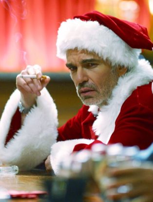 Billy Bob Thornton as Bad Santa sitting at a bar smoking a cigarette