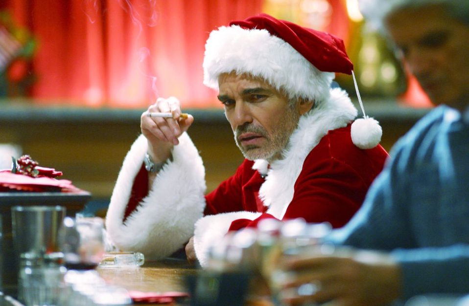 Billy Bob Thornton as Bad Santa sitting at a bar smoking a cigarette