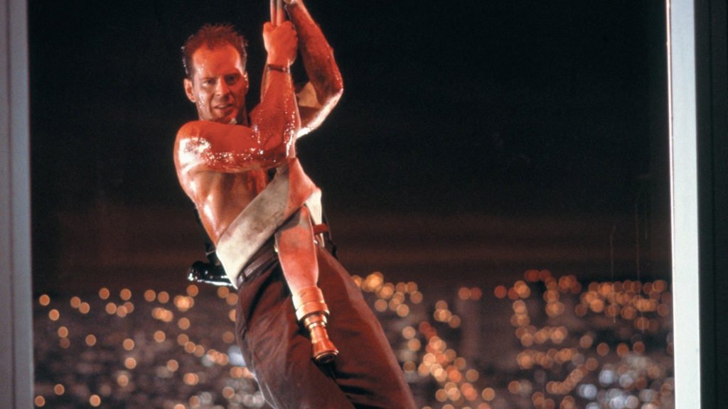 Bruce Willis in Die Hard shirtless, bleeding and repelling down the building on a fire hose wrapped around his stomach