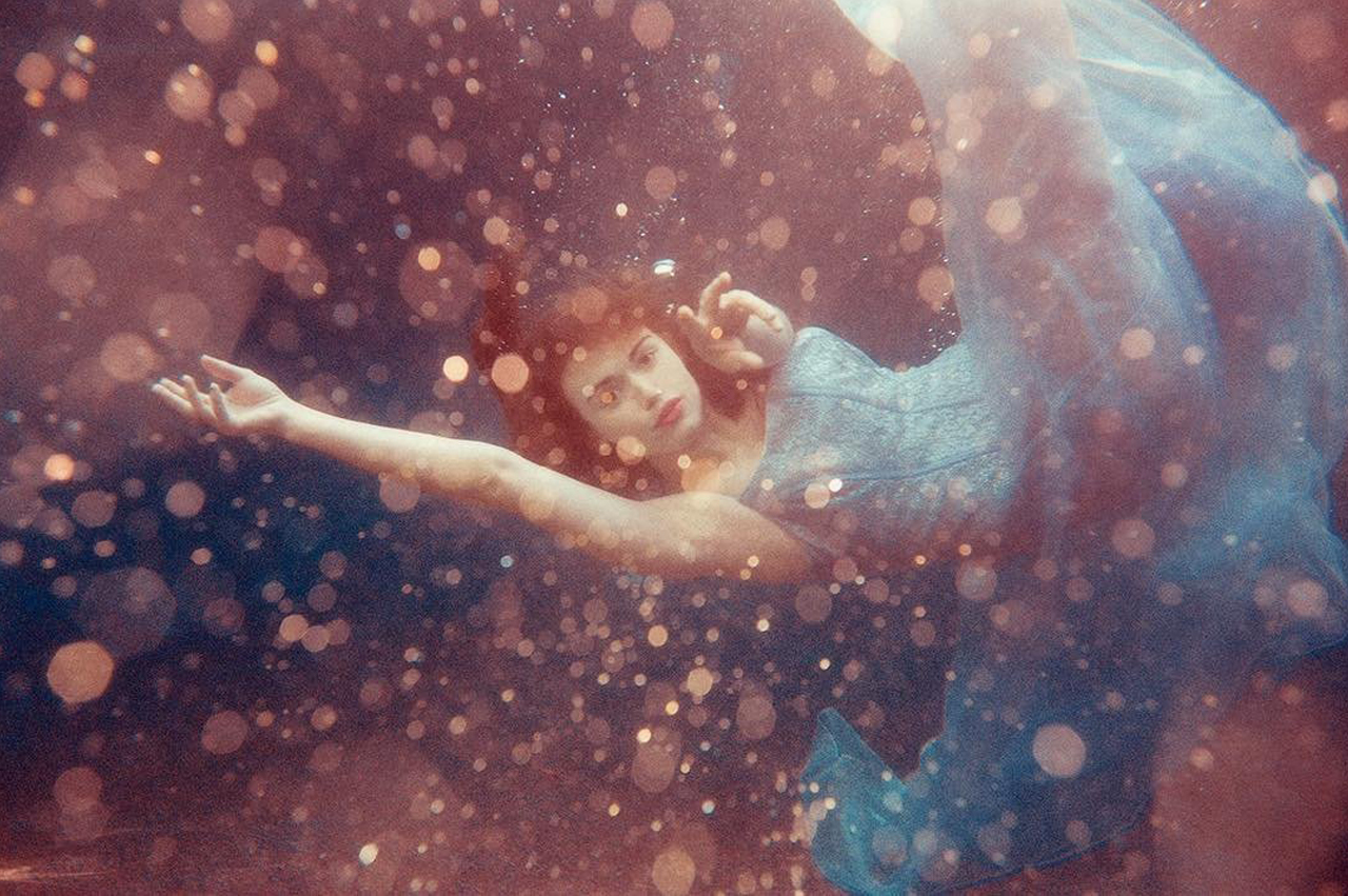 woman in dreamscape wearing a gown underwater