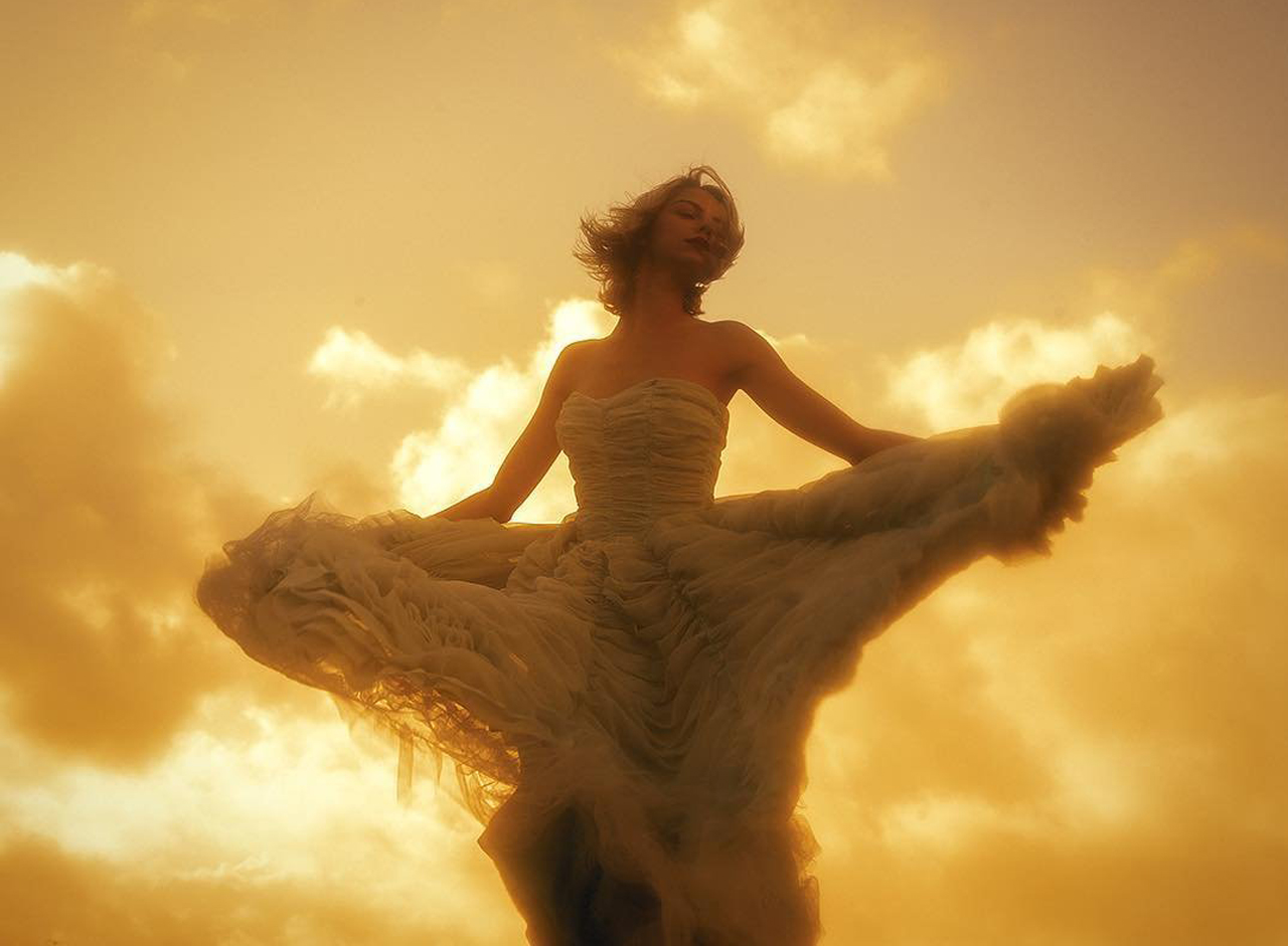 image of woman in a gown dancing at sunset