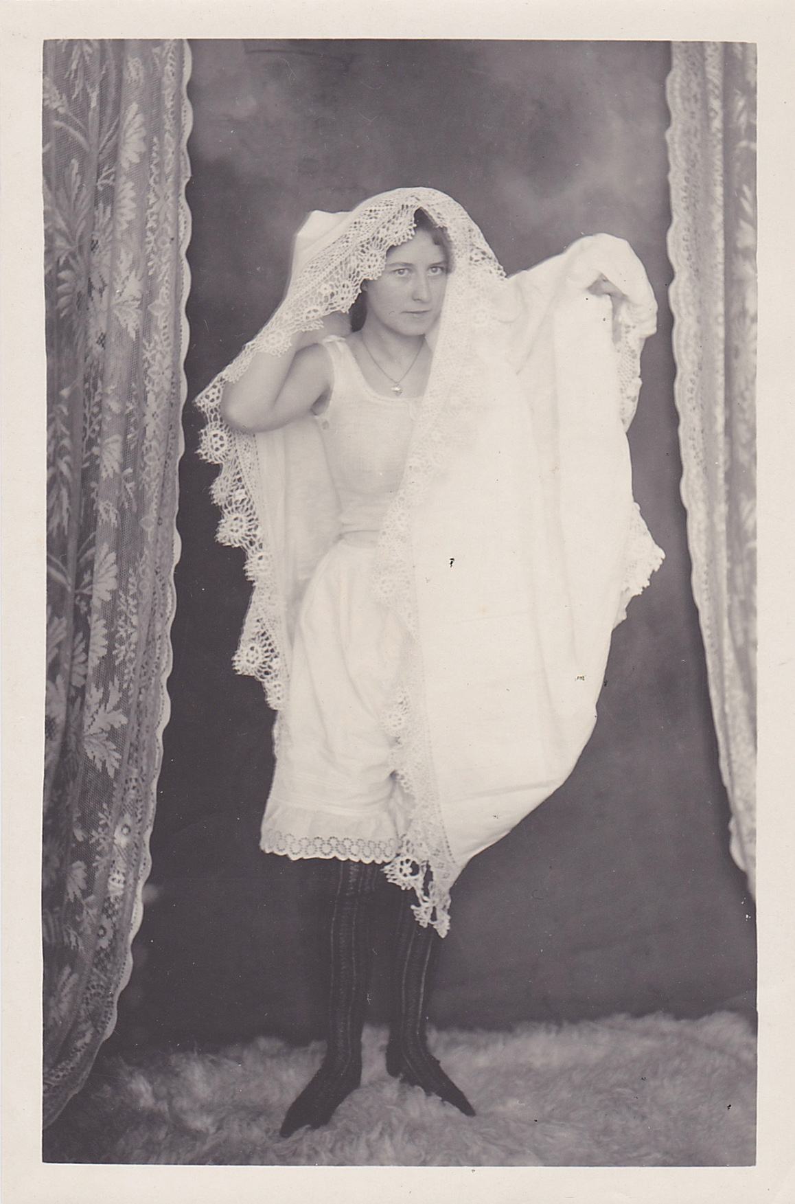antique photo of a woman wearing underwear and a tablecloth