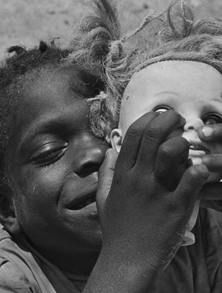 Photograph of an African boy holding a dolls head shot by Eugene Richards
