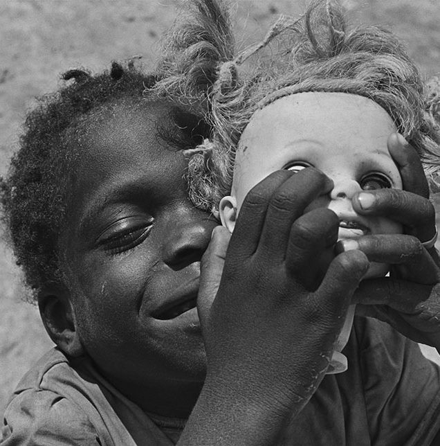 Photograph of an African boy holding a dolls head shot by Eugene Richards