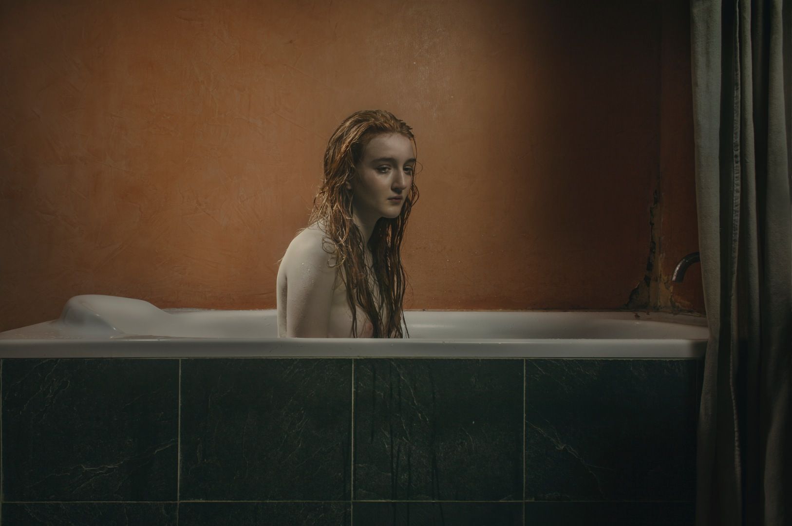 photo of a redhead girl in a bathtub, nude