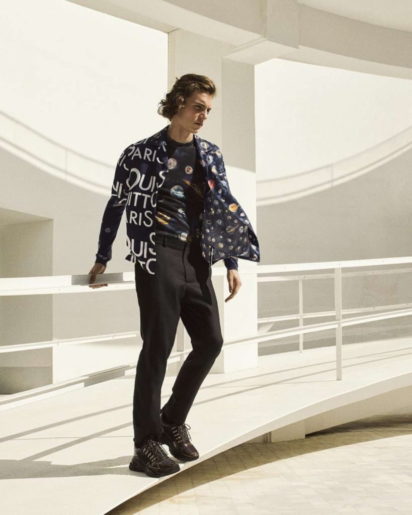 Louis-Vuitton-Male-Model-wearing-a-jacket-with-printed-words-on-the-front-and-photos-of-the-planets-on-the-inside-and-top