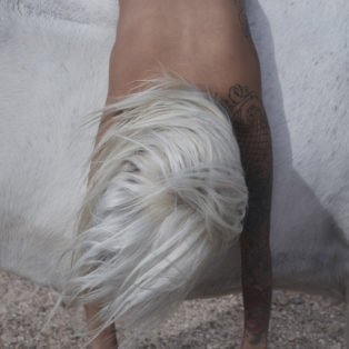 yeezy-zine-image-of-a-naked-body-with-bleach-blond-long-hair-slumped-over-a-white-horse