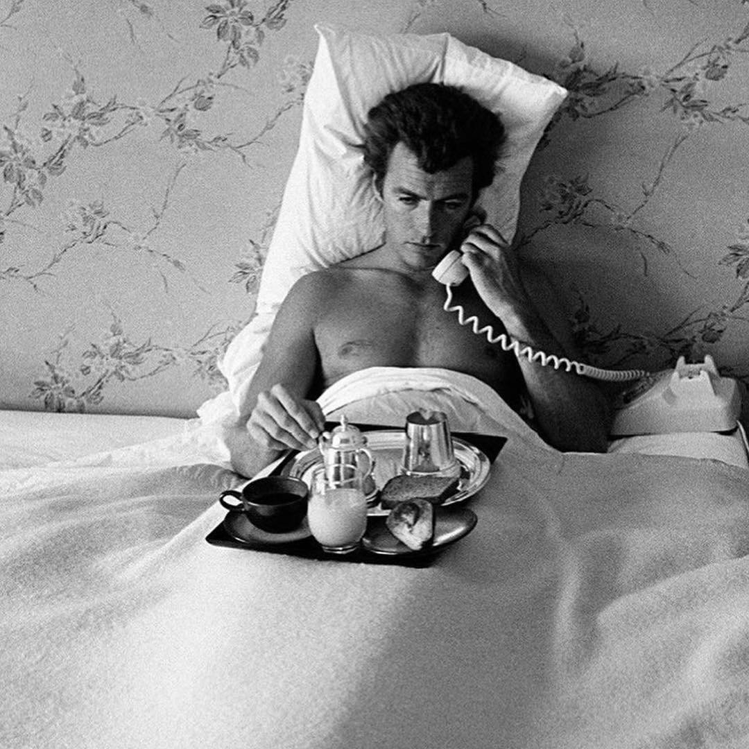 Clint Eastwood eating breakfast in bed, nude