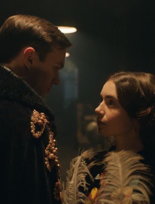 nicholas hoult-lily collins holding a feather on the film set of Tolkien