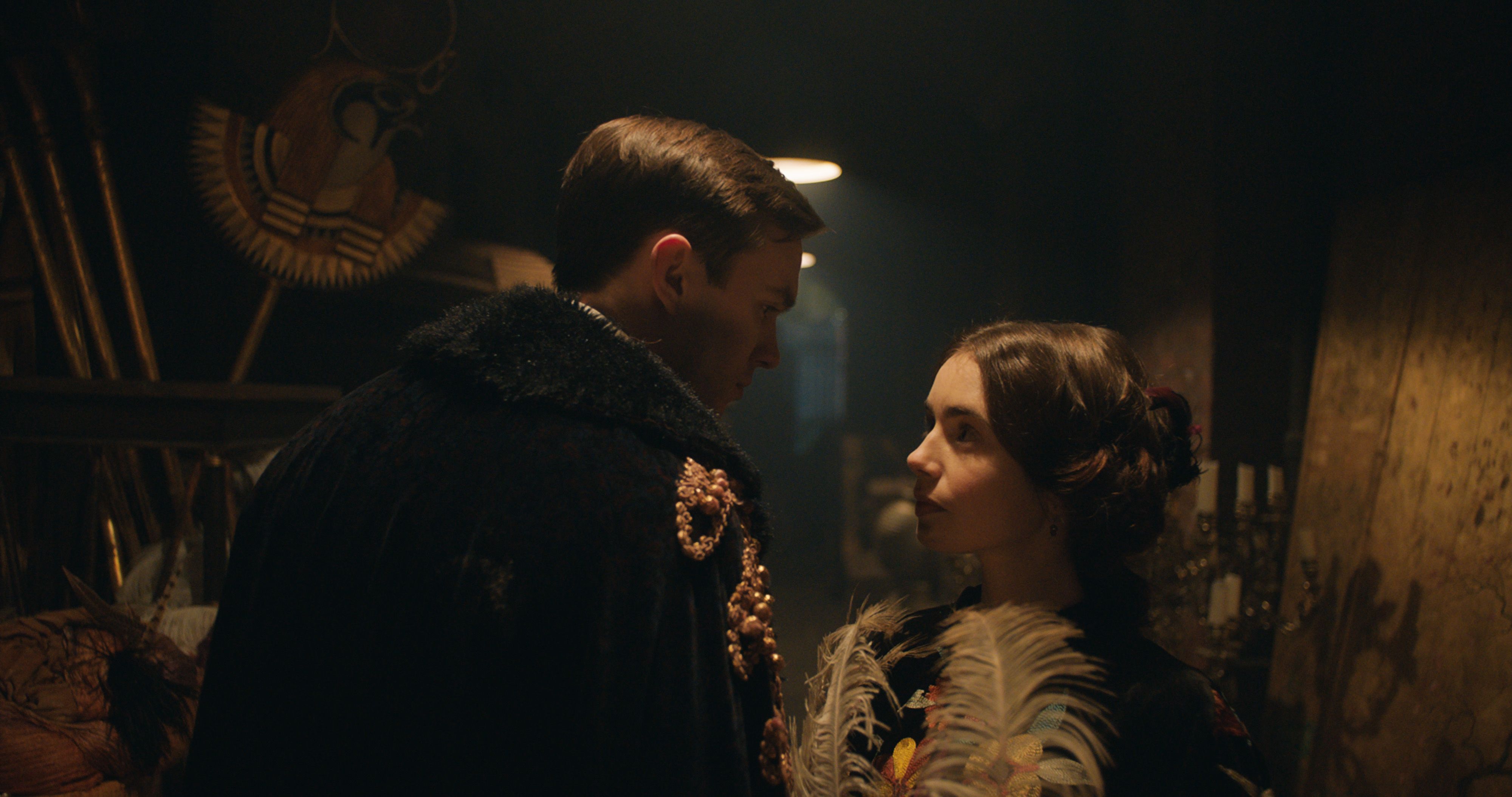 nicholas hoult-lily collins holding a feather on the film set of Tolkien