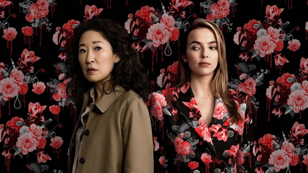 Eve wearing a beige trench coat and Vilanelle in black and pink floral blazer against matching