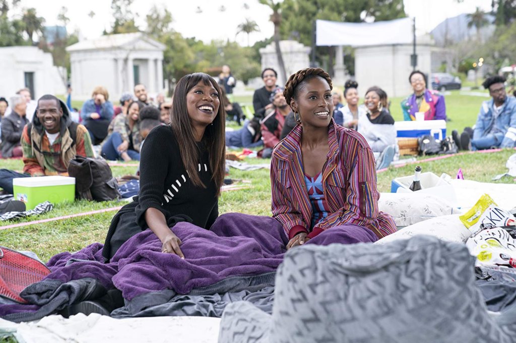 Issa Rae and best friend Molly played by Yvonne on a picnic blanket at an outdoor concert