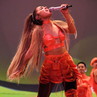 Ariana-Grande-on stage-wearing a red leather bustier-red mini skirt-summer 2019 and red thigh boots
