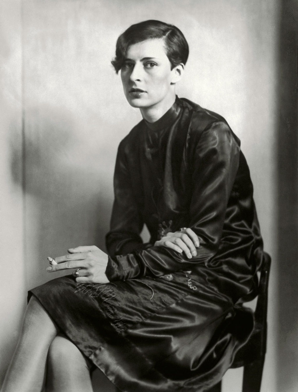 Hannah Hoch Sitting-holding a cigarette and wearing a black dress