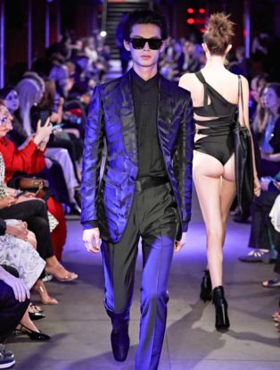Tom Ford Runway SS 2020 Male Model Wearing A Robin Blue and Black Zebra Printed Jacket and Female Model Walking the opposite way wearing a black thong showing her butt cheeks