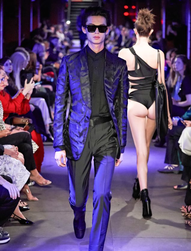 Tom Ford Runway SS 2020 Male Model Wearing A Robin Blue and Black Zebra Printed Jacket and Female Model Walking the opposite way wearing a black thong showing her butt cheeks