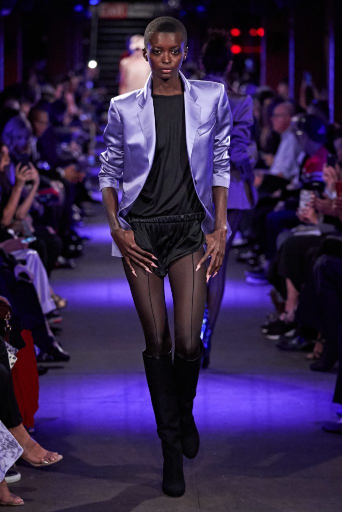 Tom Ford Runway SS 2020 Model with long nails-wearing lilac satin blazer-black skimpy running shorts and boots