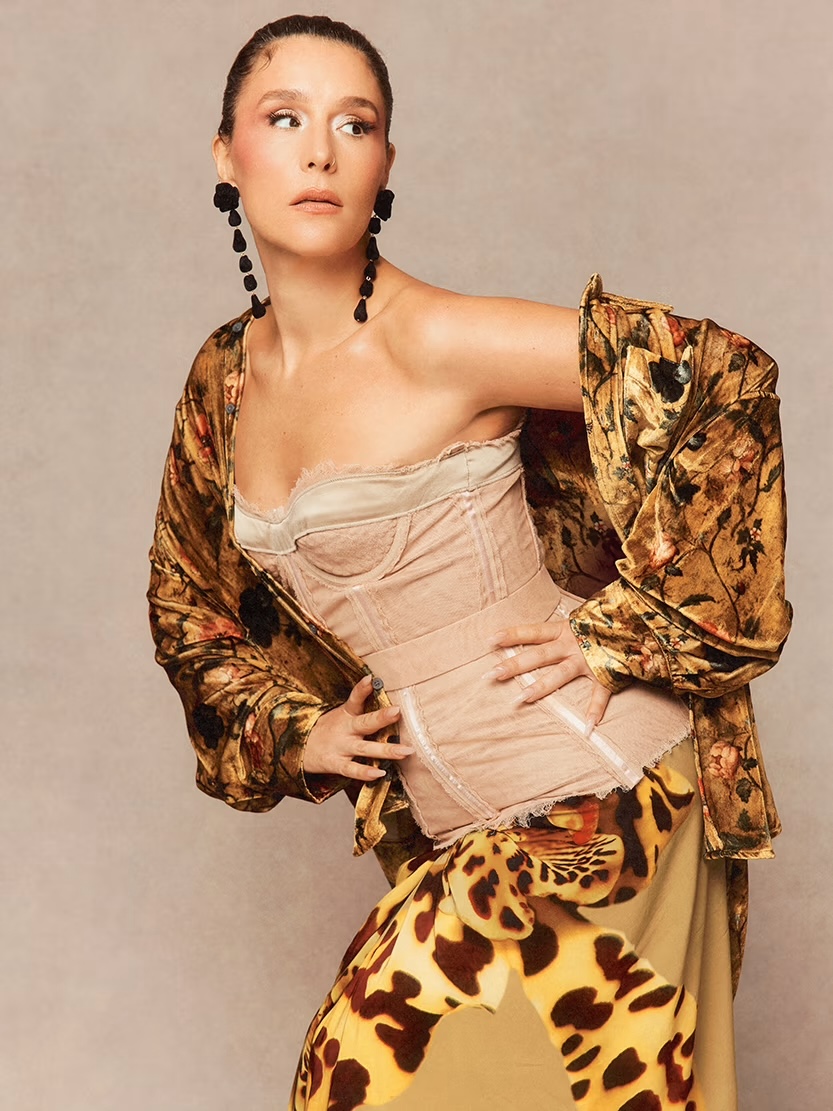 Jessie Ware posing in front of tan backdrop