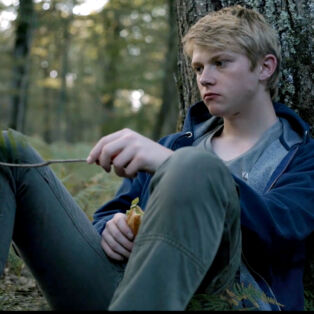 Gabriel sitting in the woods