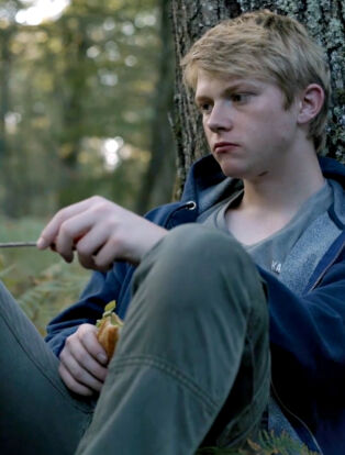 Gabriel sitting in the woods