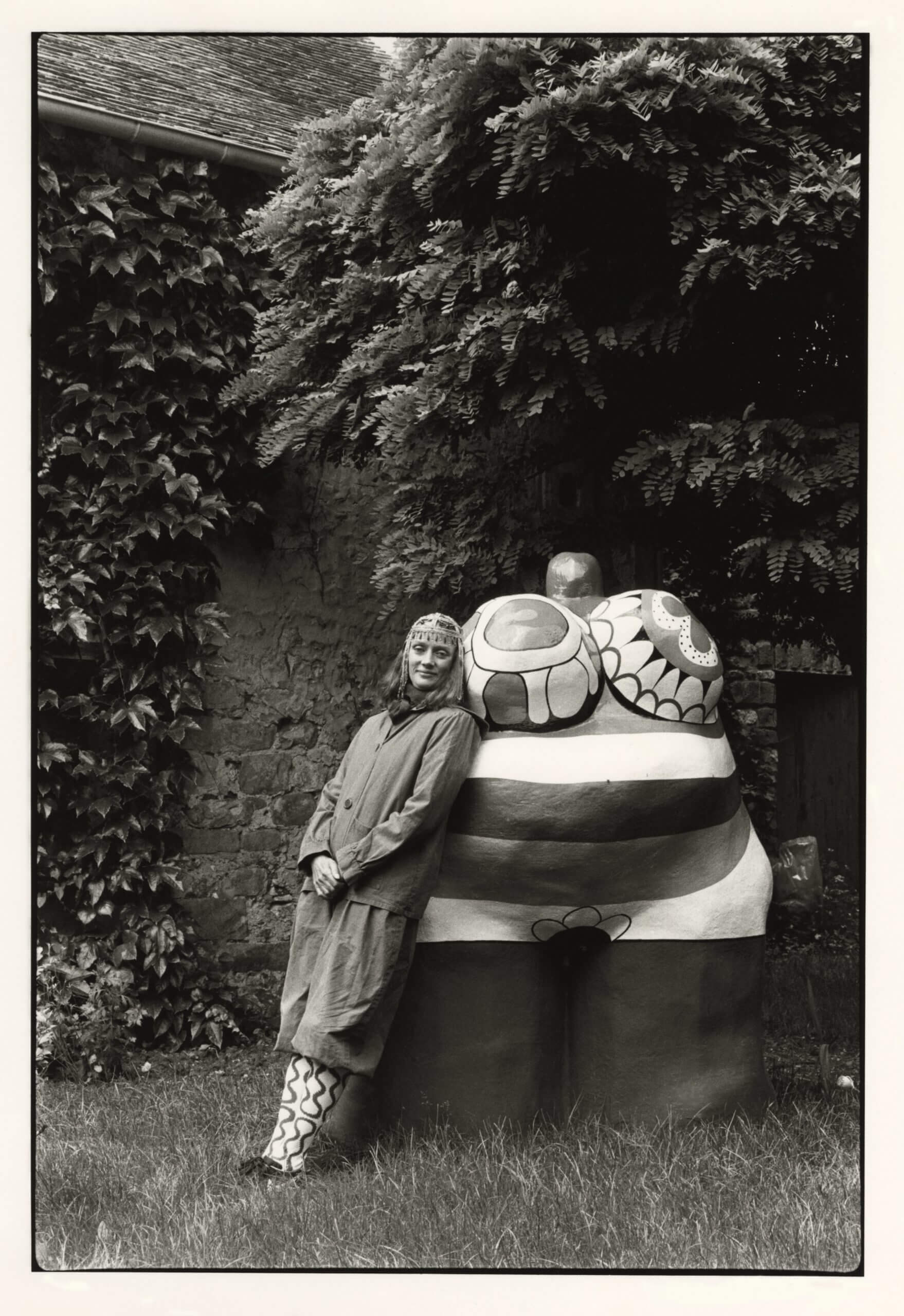 Niki with “Clarice Again” at her front garden, outside of Paris, France. 1981. Gelatin Silver Print. 12 3/16 x 8 ¼” (31 x 21 cm). Photo: Michiko Matsumoto © Michiko Matsumoto