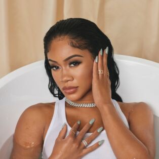 Saweetie full clothed in the bathtub
