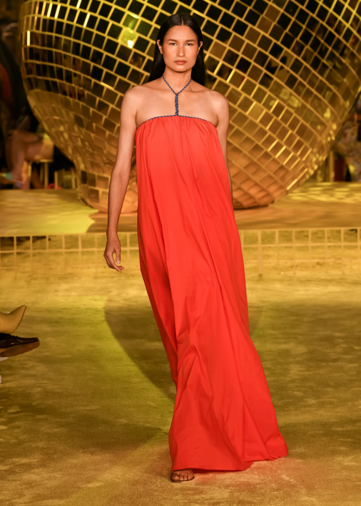 Staud Spring Summer 2022 Runway Model in Red Dress In Front of Gold Disco Ball