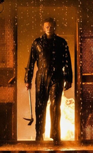 HALLOWEEN KILLS EVIL MAN IN THE DOOR FRAME OF A HOUSE ON FIRE WITH AN AX