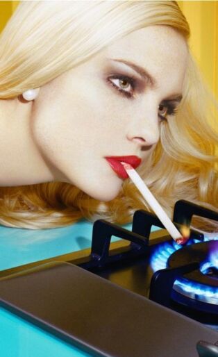 Miles Aldridge Image of Woman Lighting Her Cigarette on a stove burner flame