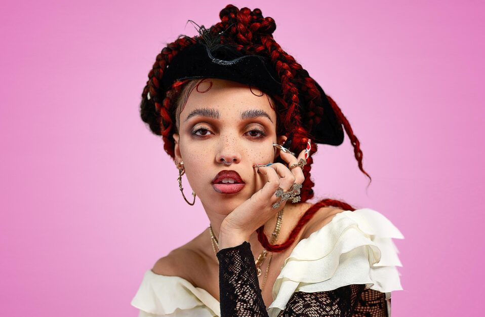 fka twigs wearing red dreds in an up hair do