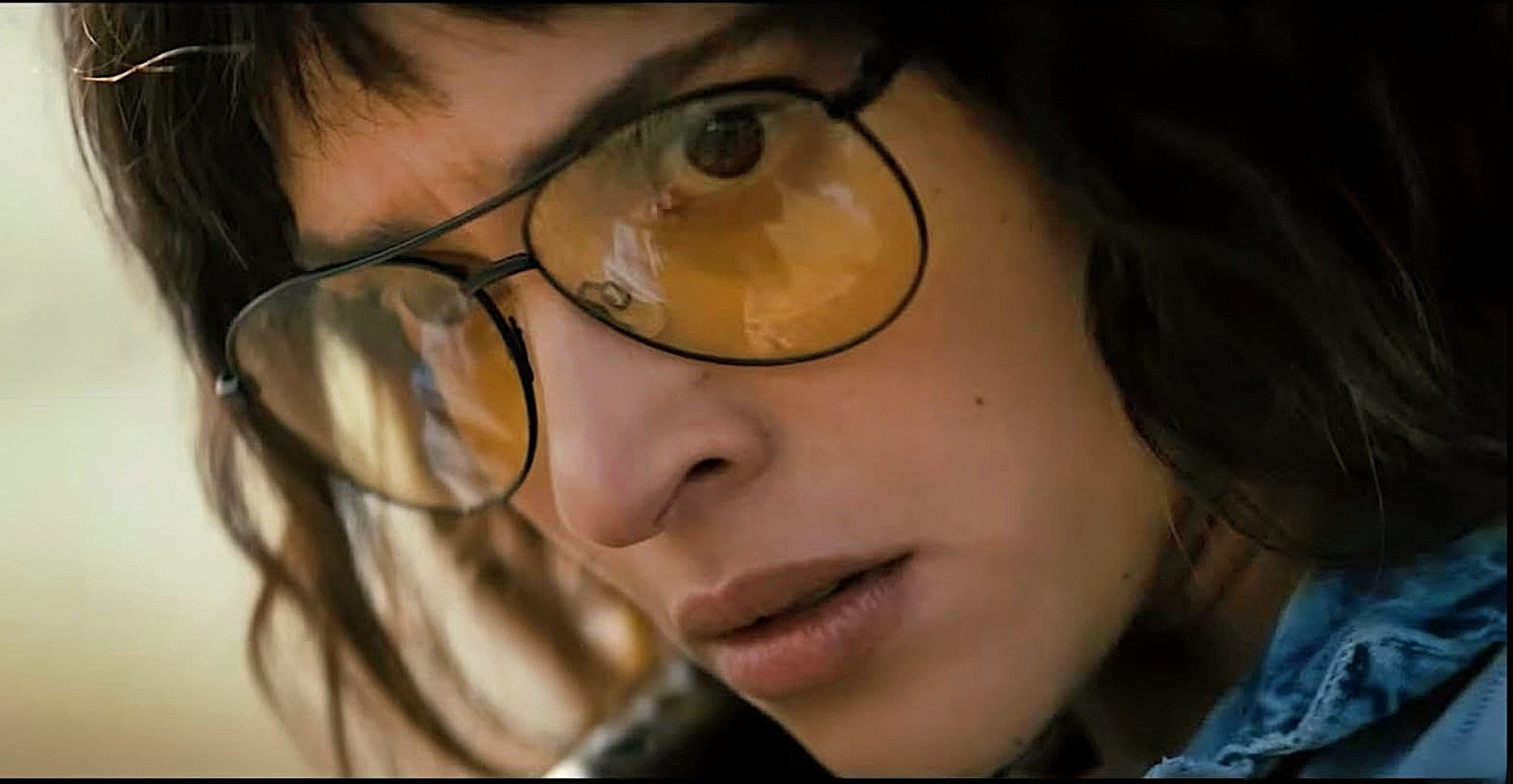 Adria Arjona in yellow glasses in Onslaught
